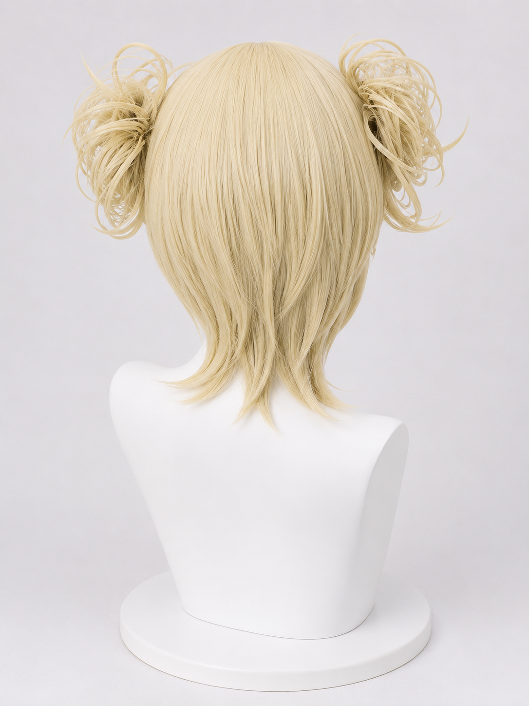 Back view of the Himiko Toga cosplay wig from My Hero Academia showcasing platinum blonde layered synthetic fibres, signature messy twin buns and realistic styling displayed on the MBCosplay signature white mannequin bust in professional commercial studio lighting.