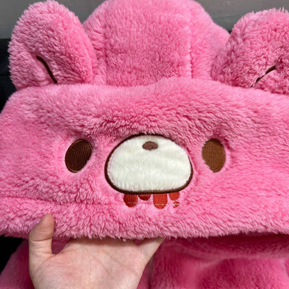 Close-up of a pink plush toy with a face held by a hand.