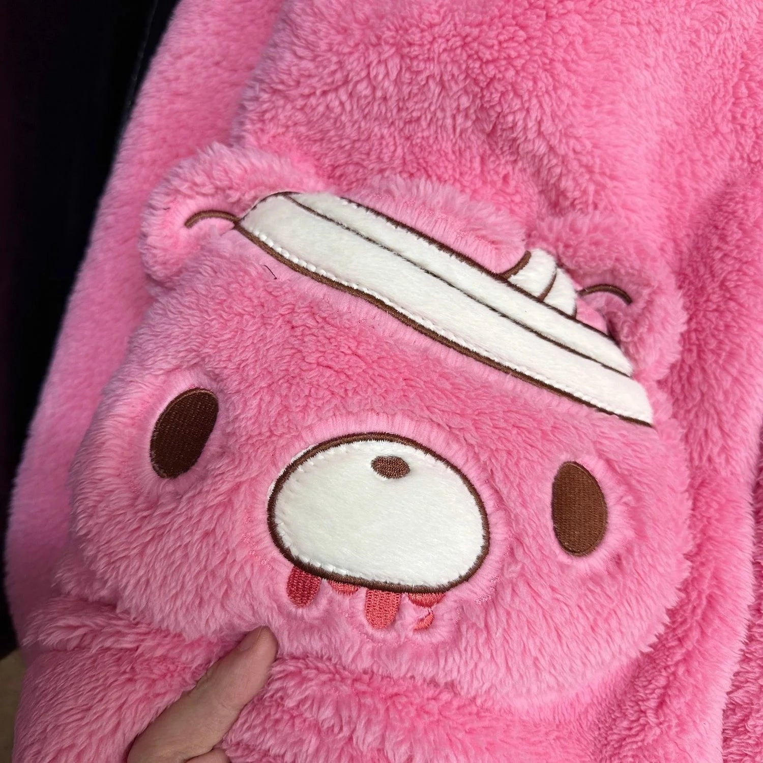 Close-up of a pink plush toy with a white stripe on its head