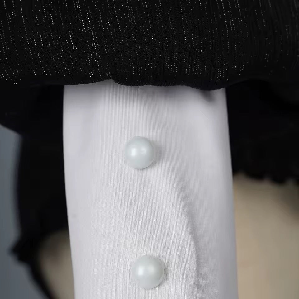 Close-up of a white shirt with pearl buttons on a mannequin against a dark background