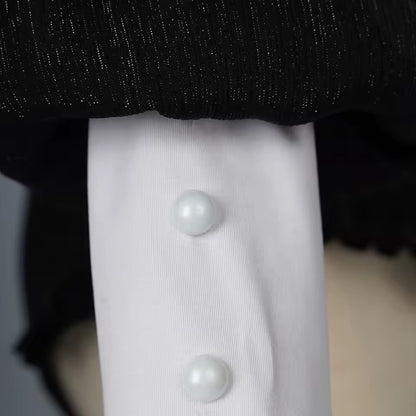 Close-up of a white shirt with pearl buttons on a mannequin against a dark background