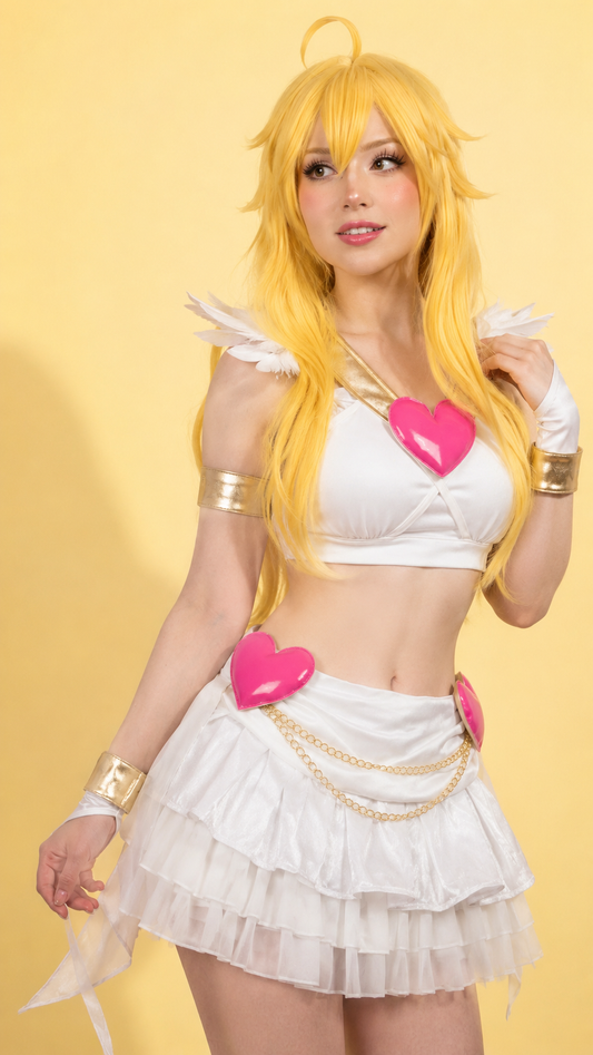 A woman modeling a white angel-themed costume with bright yellow hair, gold arm cuffs, and pink heart accents against a solid yellow background.