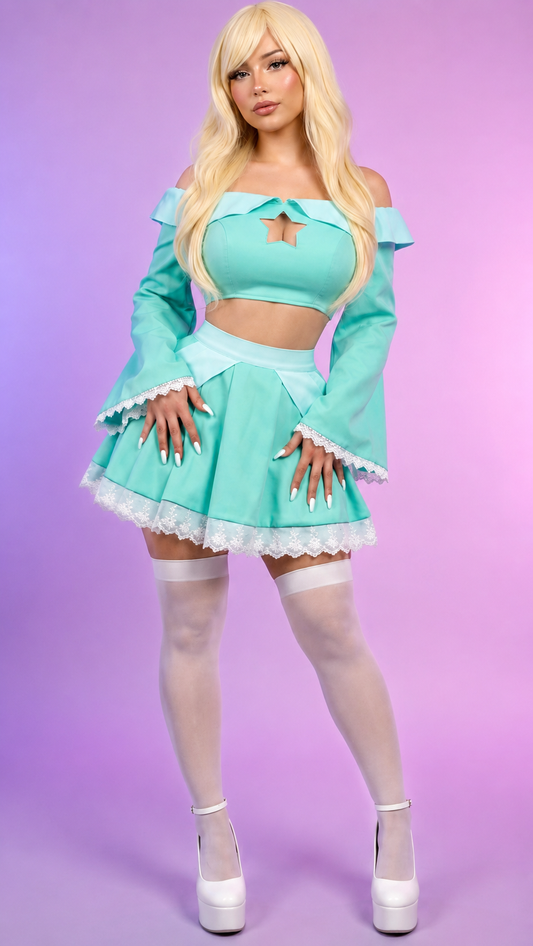 A blonde model wearing a light turquoise two-piece costume set consisting of an off-the-shoulder long-sleeve crop top with lace trim and a matching mini skirt with white lace hem, styled with white thigh-high stockings and white platform heels against a purple gradient background.