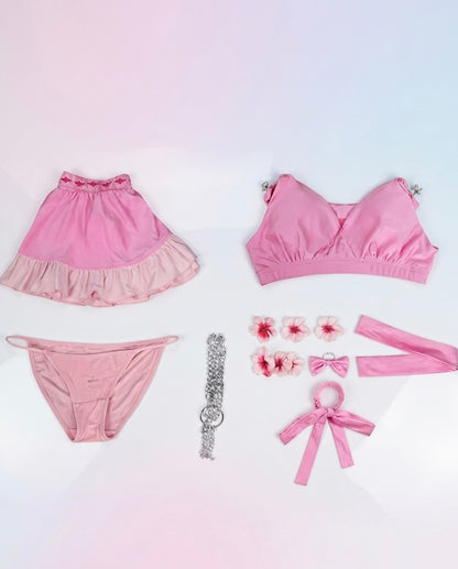 Pink women's lingerie set with accessories on a gradient background