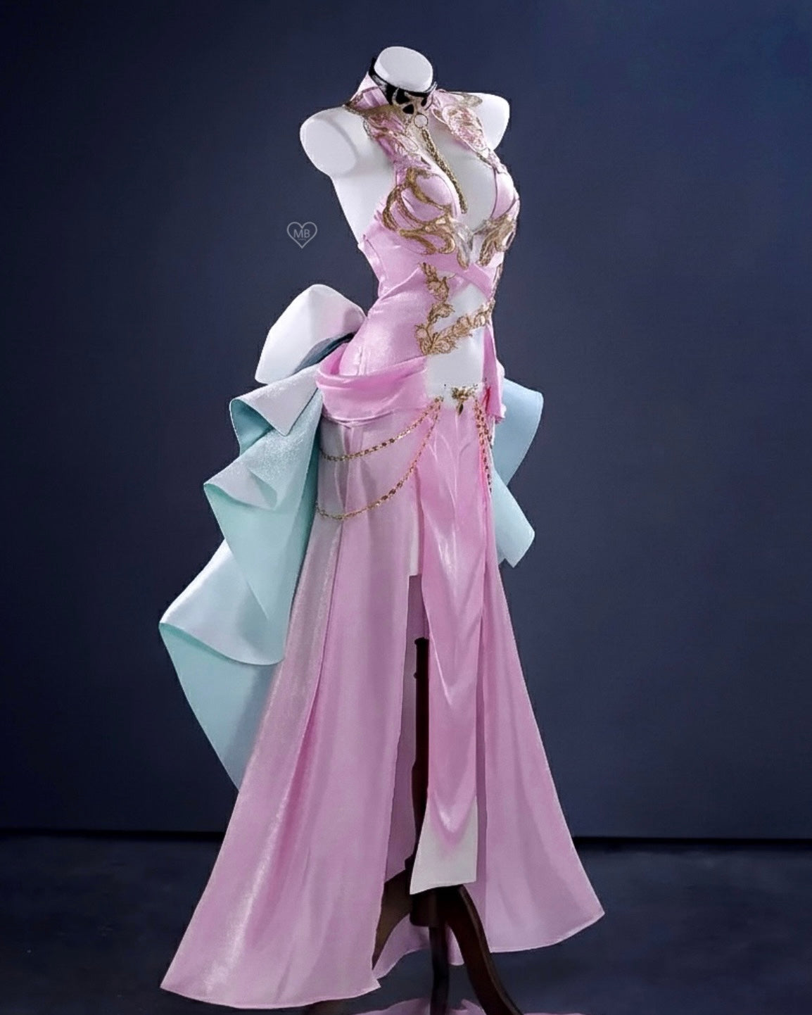 Side view of the C.C. cosplay costume showing the light blue tiered bustle and gold chain accents on the pink skirt.