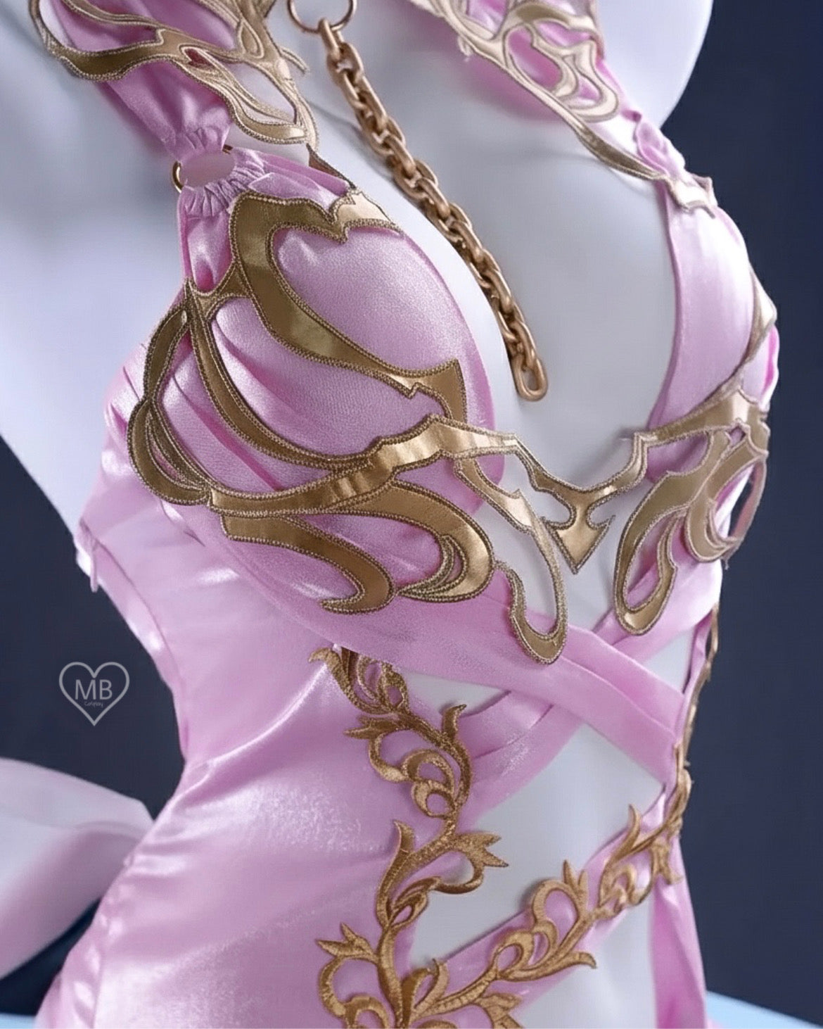 Detailed close-up of the gold lace and filigree patterns on the bodice of the C.C. pink cosplay dress