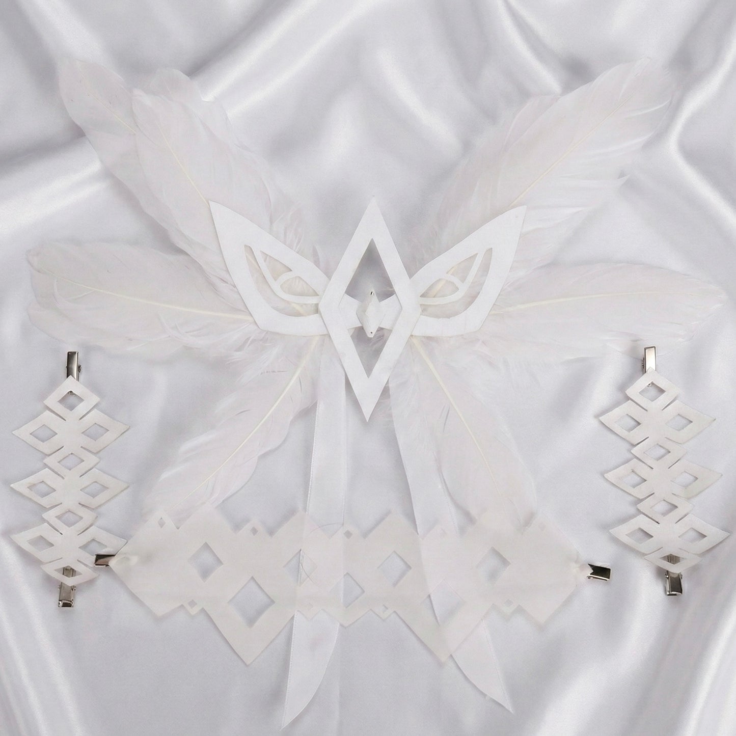 White geometric earrings on a white fabric background