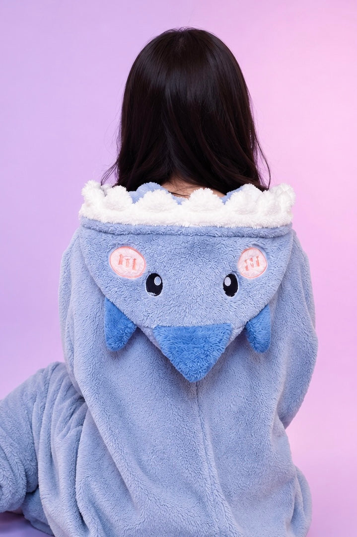 Person wearing a blue animal-themed robe with a white hood against a purple background