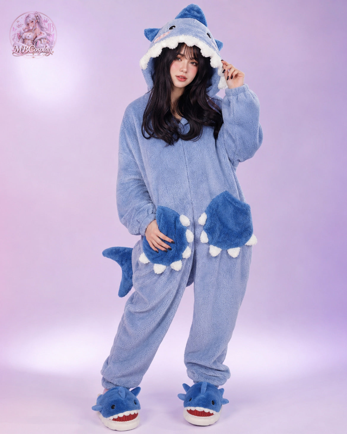 Person wearing a blue shark onesie against a light purple background