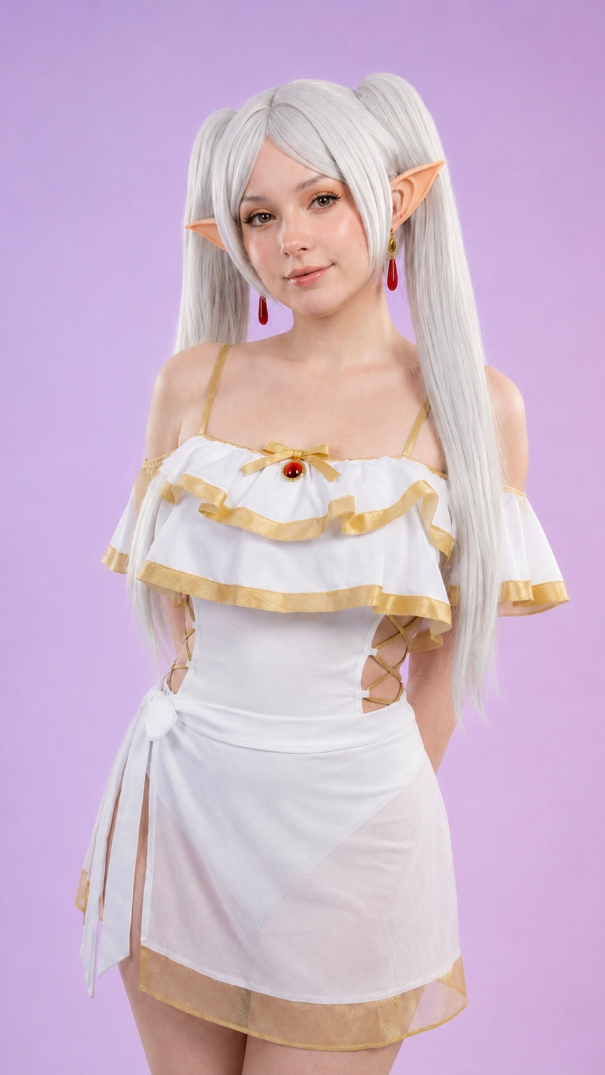 Female model wearing Frieren swimsuit cosplay costume featuring white and gold fantasy outfit, silver twin-tail wig, elf ears and detailed anime-inspired design in professional studio photography.