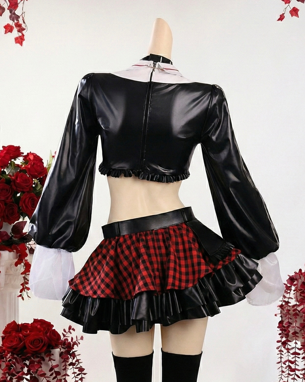 Black leather crop top and red plaid skirt with white gloves on a white background