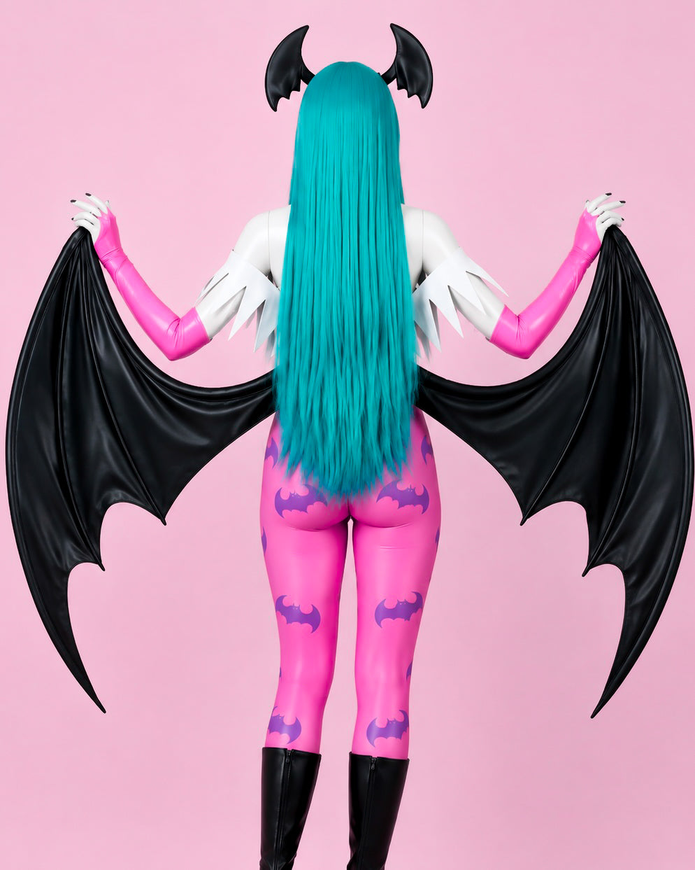 Back view of Morrigan Aensland Darkstalkers cosplay costume showing black reverse bat wings, pink tights and teal wig