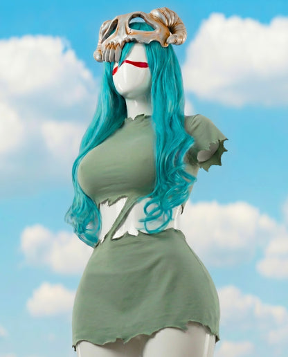 Mannequin with blue hair and green outfit against a cloudy sky background
