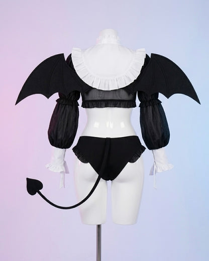 Black and white lingerie set with bat wings on a mannequin against a light purple background