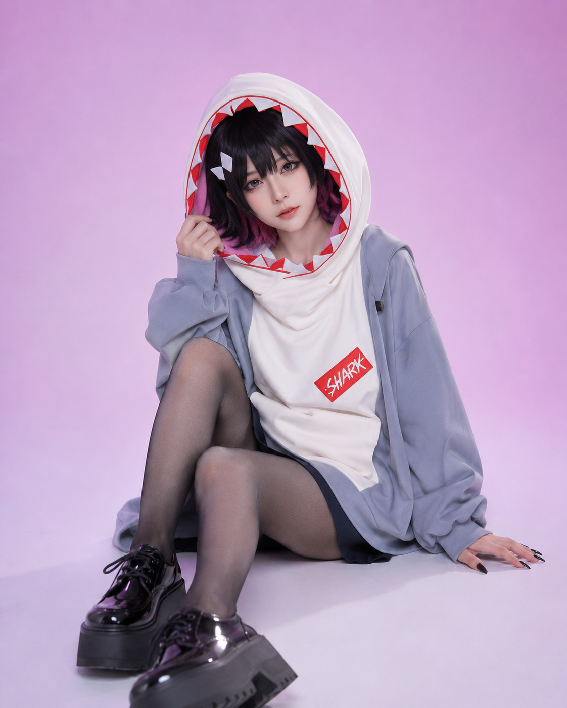 Cosplay model wearing the oversized blue-gray Sharkboo Bangboo hoodie with shark teeth trim hood design and red shark patch.