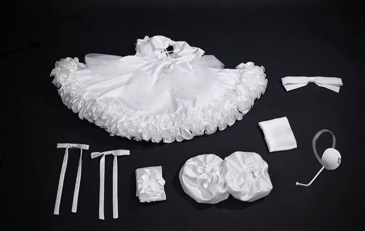 Sua Zombie Stage cosplay pieces laid out with white ruffled dress, bows, sleeve accessories, headwear and headset prop