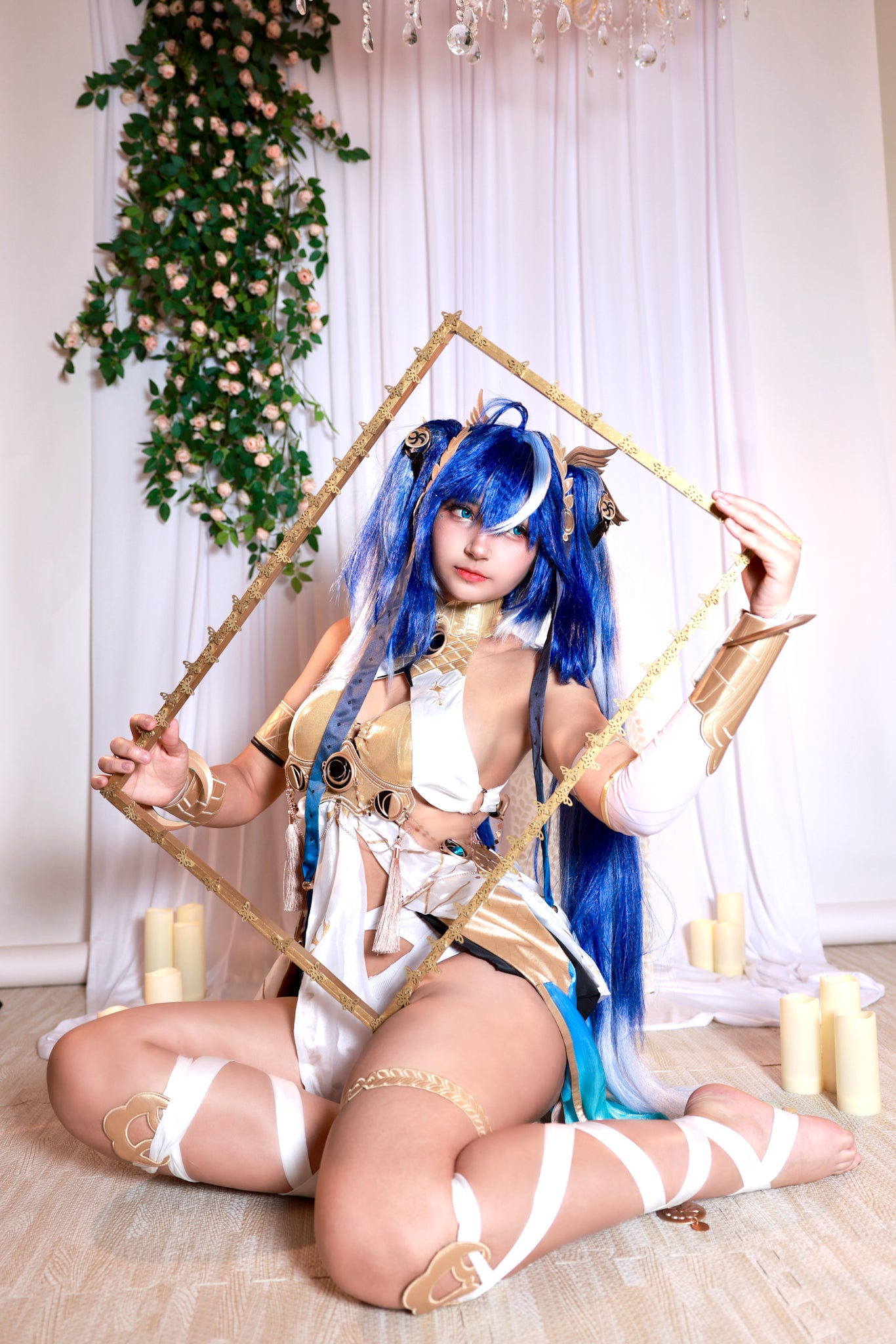 Person with blue hair and cosplay outfit posing with a decorative frame.